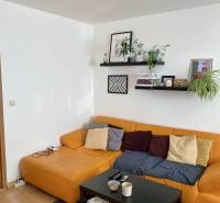 Wohnzimmer mit gelbem Sofa und schwarzem Tisch in einer 3-Zimmer-Wohnung.