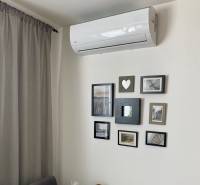 Klimaanlage und gerahmte Fotos an der Wand in einer 3-Zimmer-Wohnung.