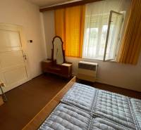 Schlafzimmer im Einfamilienhaus mit Fenster, Spiegel und Bett mit gestepptem Matratze.