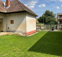 Ein Einfamilienhaus in Trenčianske Stankovce mit einem Rasen-Grundstück und einem Ziegeldach.