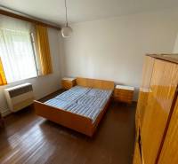 Schlafzimmer in einem Einfamilienhaus mit Holzboden, Bett und Schränken.