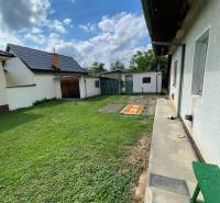 Der Garten des Einfamilienhauses in Trenčianske Stankovce mit grünem Rasen und Anbau.