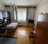 Esszimmer in einem Einfamilienhaus mit Holzboden, einfachem Tisch und Wandschrank.