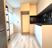 Küche in einer 4-Zimmer-Wohnung mit Holzboden, eingebauten Geräten und Stauraum.