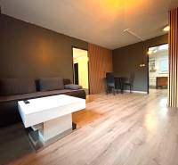 Wohnzimmer mit grauem Sofa, weißem Tisch und Essecke in einer 4-Zimmer-Wohnung.