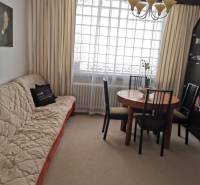 Wohnzimmer mit Sofa, Esstisch und Kronleuchter in einem Einfamilienhaus.