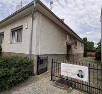 Ein Einfamilienhaus in Topoľčianky mit einem Eingang und einem Tor an einer steinigen Straße.