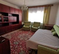 Ein Zimmer in einem Einfamilienhaus, enthält ein Bett, Sofas, einen Teppich und einen Wandschrank.