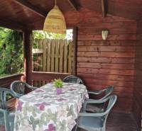 Ein hölzerner Pavillon im Einfamilienhaus in Topoľčianky, mit Plastikstühlen und einem dekorierten Tisch.