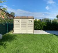 Der Garten des Einfamilienhauses in Vojka nad Dunajom mit Rasen und Gartenhaus.