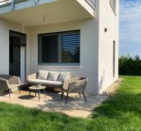 Ein Einfamilienhaus in Vojka nad Dunajom mit Terrasse, Gartenmöbeln und Rasen.