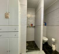 Badezimmer im Einfamilienhaus mit Keramikfliesen und Stauraum.