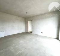 Ein leerer Innenraum in einem Einfamilienhaus mit einem großen Fenster, weiße Decke und Wände.