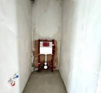 Ein unvollendeter Raum in einem Einfamilienhaus mit Anschlüssen für ein Waschbecken oder eine Toilette.