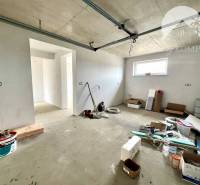 Unvollendetes Interieur eines Einfamilienhauses mit verteiltem Baumaterial und neuen Wänden.