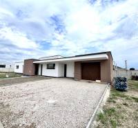 Ein Einfamilienhaus in Miloslavov mit Ziegelverkleidung und großem Parkplatz, klarer Himmel.