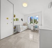 Kinderzimmer im Einfamilienhaus mit Bett, Tisch und Schrank.
