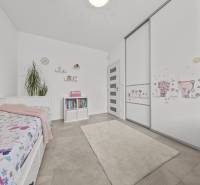 Kinderzimmer in einem Einfamilienhaus mit Bett, Bücherregal und Kleiderschrank mit Kindermotiv.
