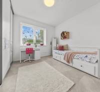 Kinderzimmer in einem Einfamilienhaus mit Schreibtisch, Bett und Schrank.