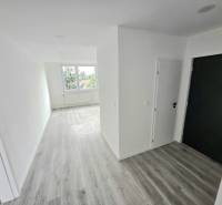 Ein heller Flur und Boden in einer 3-Zimmer-Wohnung mit einem großen Fenster.