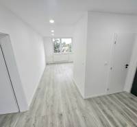 Flur in einer 3-Zimmer-Wohnung mit Holzboden und weißen Wänden.
