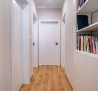 Chodba in einem Einfamilienhaus mit Holzboden und einem Bücherregal voller Bücher.