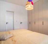 Schlafzimmer in einem Einfamilienhaus mit großem Bett, Schrank und Hängelampe.