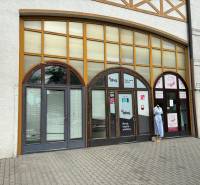 Geschäftsräume in der Petöfi-Straße in Komárno mit großen Fenstern und einer Schaufensterpuppe.