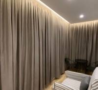 Vorhänge in einem farblich abgestimmten Interieur, Sofa und Sitzecke im Ferienapartment.