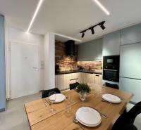 Küche in der Ferienwohnung mit Esstisch, Ziegelverkleidung und modernen Geräten.