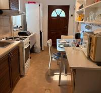 Küche in einem Einfamilienhaus mit Esstisch, Geräten und Stauraum.
