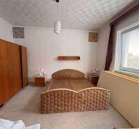 Schlafzimmer in einem Einfamilienhaus mit einem großen Bett und Holzschränken.