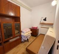 Ein kleiner Raum mit antiken Möbeln und einem ausziehbaren Bett in einem Einfamilienhaus.