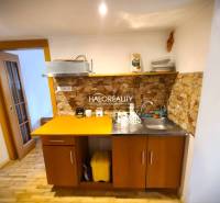 Eine Küche in einem Einfamilienhaus mit Holzmöbeln und Steinverkleidung.