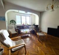 Wohnzimmer in einem Einfamilienhaus mit Sesseln und einem braunen Sofa.