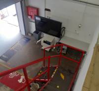 In Lagern und Hallen gibt es eine rote Treppe, einen Bildschirm und einen offenen Eingangsbereich.