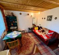 Wohnzimmer in einer Hütte mit Holzdecke, gemusterten Teppichen und bequemen Sitzgelegenheiten.