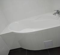 Weiße Badewanne mit Armatur im Badezimmer eines Einfamilienhauses.