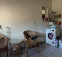 Waschküche in einem Einfamilienhaus mit Waschmaschine, Kessel und Holzmöbeln.