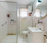 Badezimmer mit Waschbecken, Dusche und Toilette in einem Einfamilienhaus.