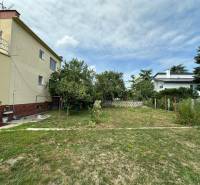 Der Garten beim Einfamilienhaus in der Božena Němcová-Straße in Komárno mit Grünflächen und Bäumen.