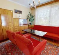 Wohnzimmer in einem Einfamilienhaus mit roten Sofas und Holzmöbeln.
