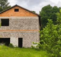 Ein unvollendetes Einfamilienhaus in Čelovce, umgeben von üppigem Grün und Rasen.