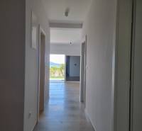 Flur in einer 4-Zimmer-Wohnung mit Blick auf das Äußere und Grünflächen.
