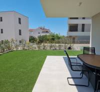 Garten einer 4-Zimmer-Wohnung in Vodice mit Terrasse und modernem Tisch auf dem Rasen.
