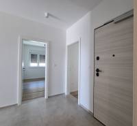Eingangsflur in einer 4-Zimmer-Wohnung mit Holztüren und Fliesenboden.