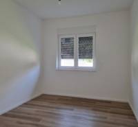 Leerer Raum mit Holzboden und Fenster, 3-Zimmer-Wohnung.