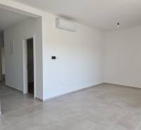 Helles Zimmer in einer 3-Zimmer-Wohnung mit Fliesenboden und Klimaanlage.