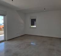 Geräumiges Zimmer einer 4-Zimmer-Wohnung mit Blick nach draußen durch Balkontüren.