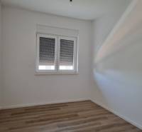 Innenraum einer 4-Zimmer-Wohnung mit weißen Wänden und Holzboden.